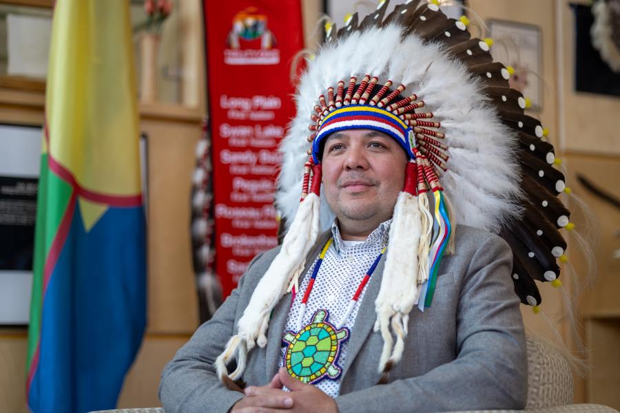 Headshot of Chief Gordon Bluesky wearing traditional Indigenous headwear.