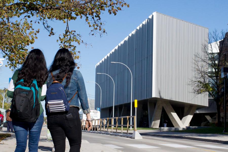 Two students walk together towards the School of Art ArtLab building. 