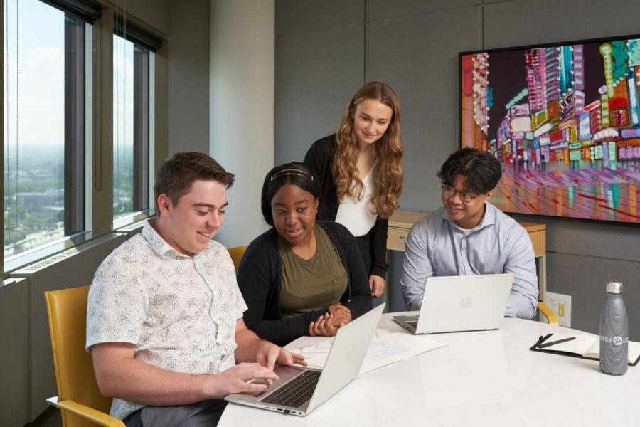 Students working at laptops in Deloitte Boardroom - Asper Co-op
