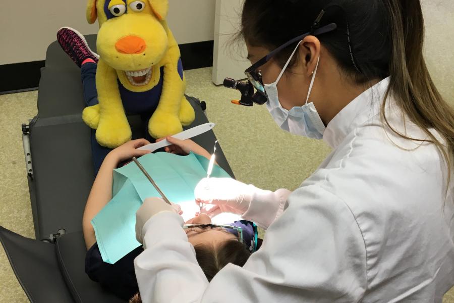 A dental hygiene student working on a youth patient, in clinic.