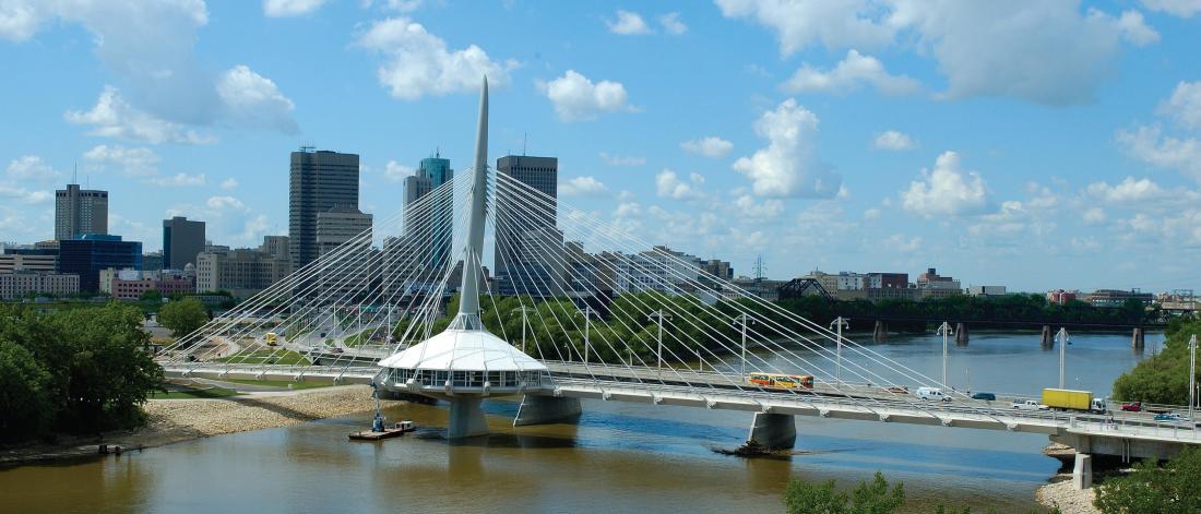 A scenic city scape of Winnipeg Manitoba prominently featuring the Provencher Bridge.