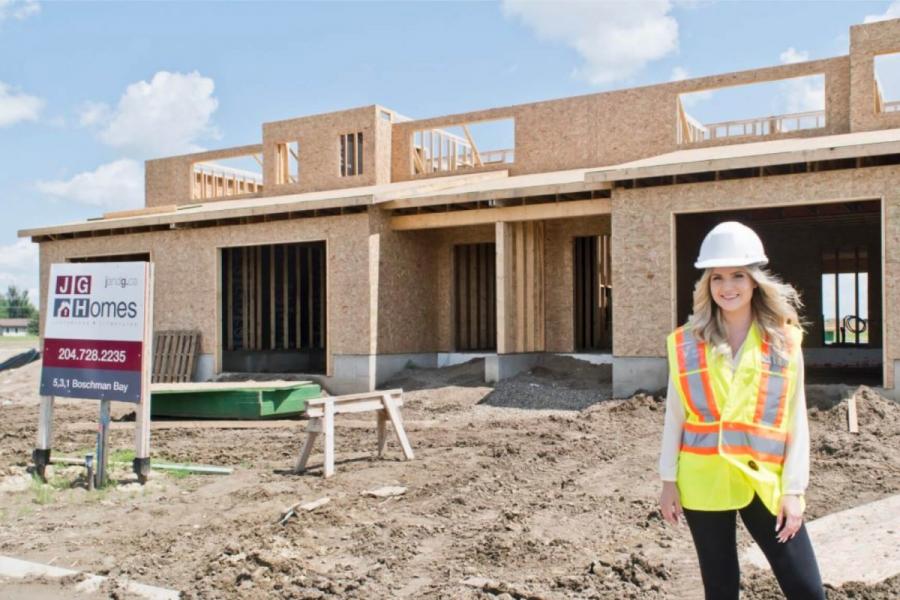 An architecture student stands in front of a partially built home for J and G homes where she is participating in a co-operative integrated work program.