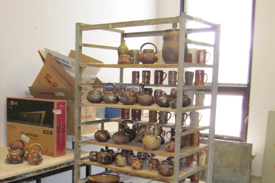 A shelving unit filled with finished ceramic pieces.