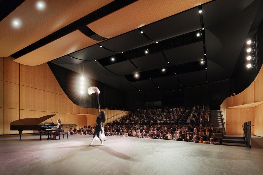 A performer on stage at the desautels concert hall dances while another person plays a grand piano.
