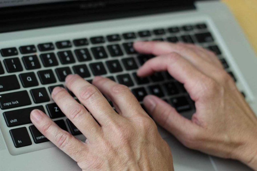 Hands on a laptop keyboard.
