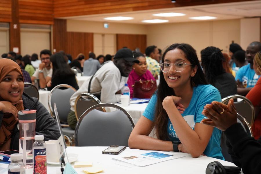 Volunteer smiles at a table with new students