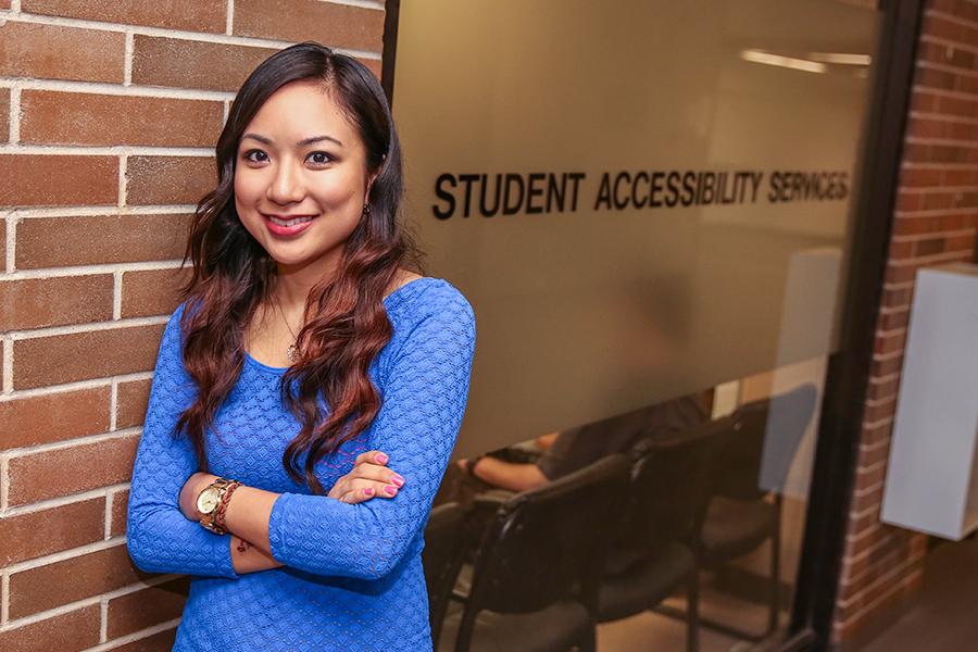 A student in front of the Student Accessibility Services office