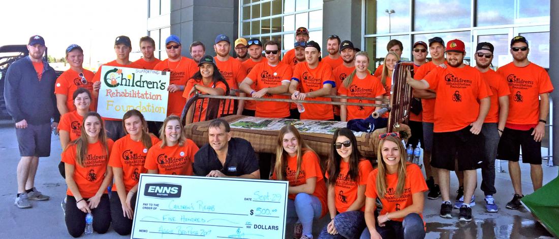 A group of students standing together with a cheque they are presenting to the Children's Rehabilitation Foundation from funds raised in the Aggie Bed Push in 2017.