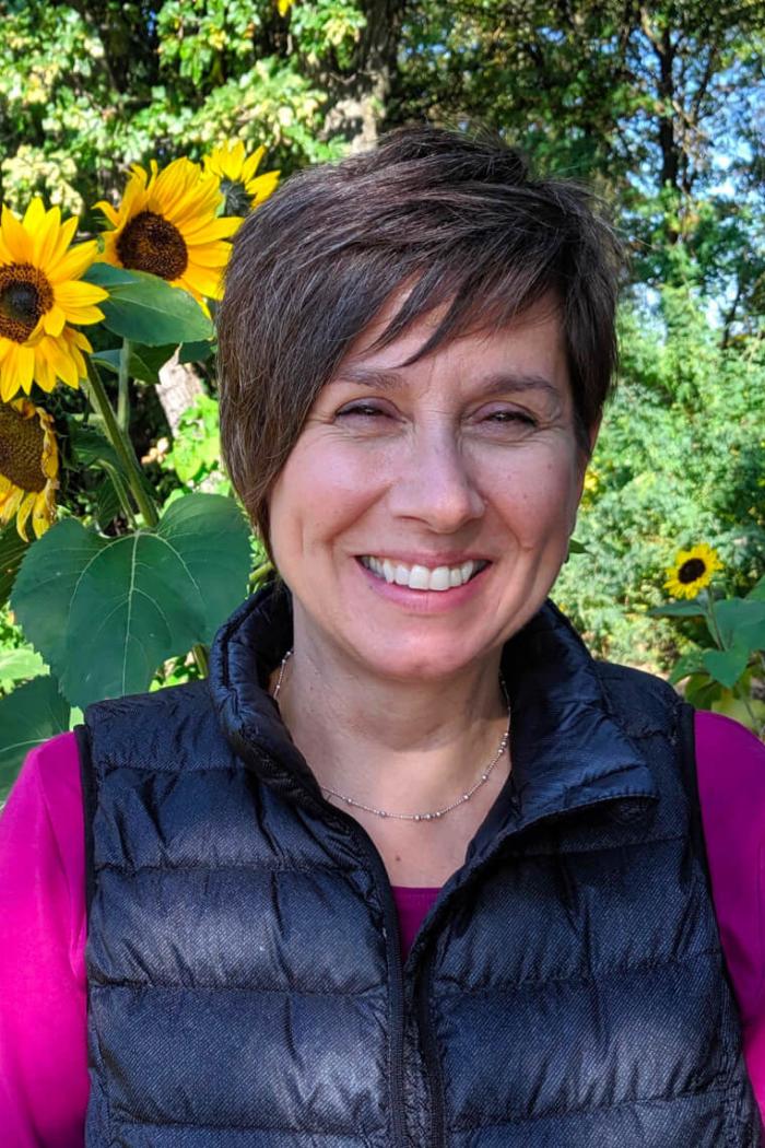 Researcher Joyce Slater standing in front of some sunflowers.