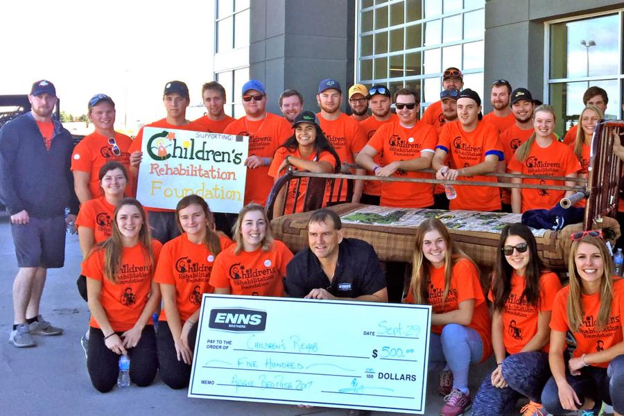 A group of students standing together with a cheque they are presenting to the Children's Rehabilitation Foundation from funds raised in the Aggie Bed Push in 2017.