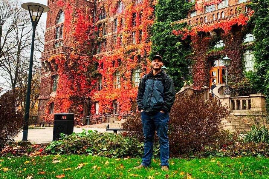 A student stands outside of a building.