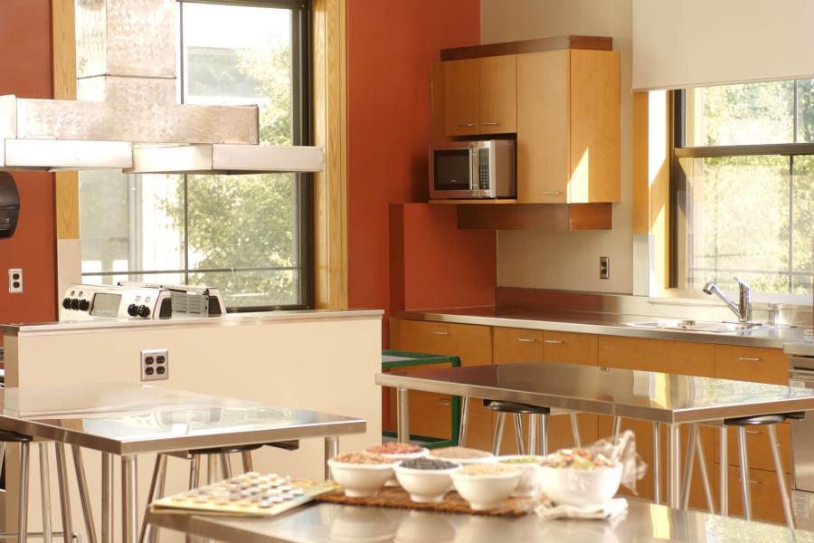 A test kitchen with stainless steel tables and stoves.
