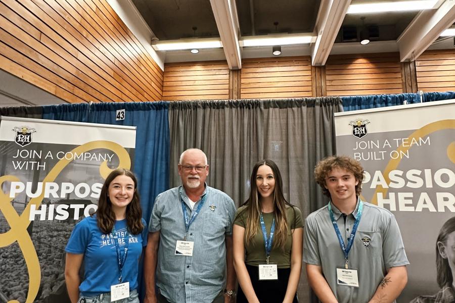 Company reps stand at career fair booth