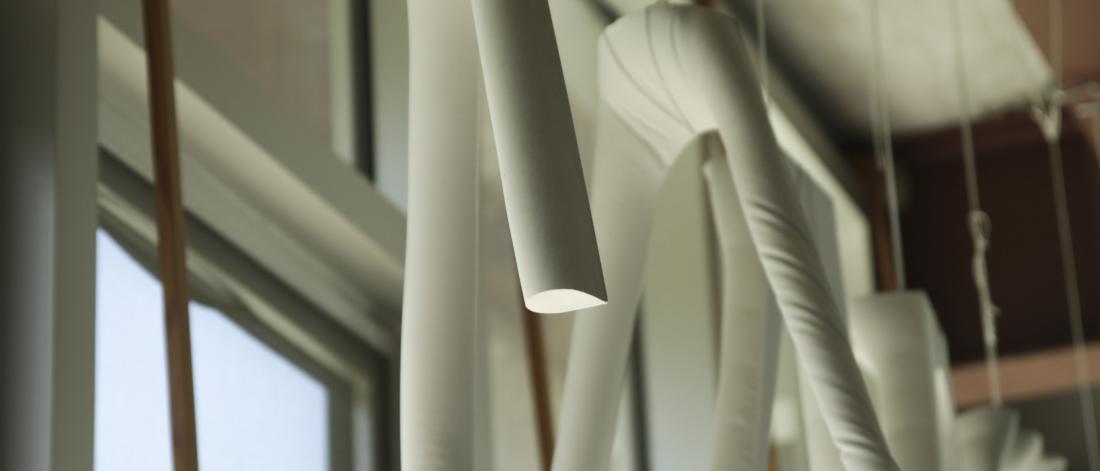 plaster molds hanging from the ceiling in front of a window