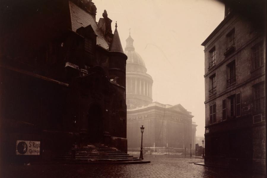 An old photograph of a street and buildings.