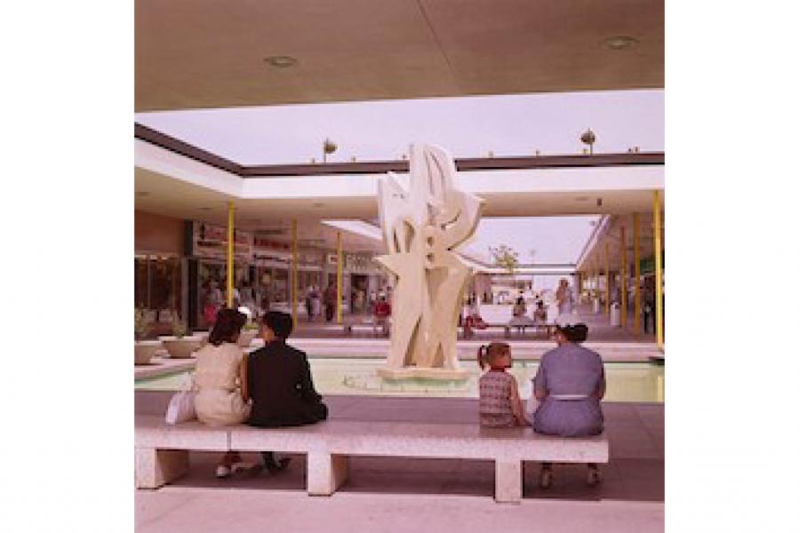 people sitting in a courtyard in front of a fountain
