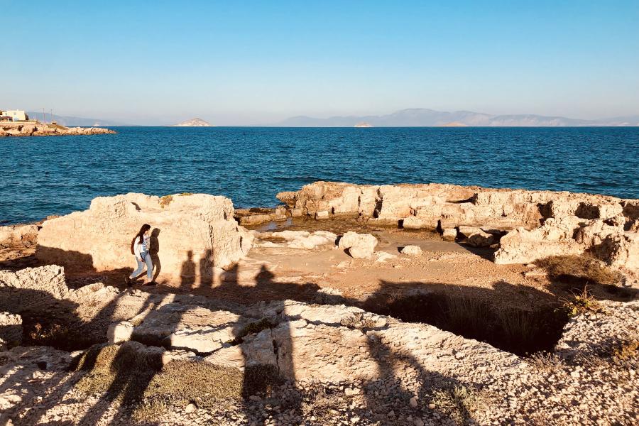 A group of people walking on rocks by the water