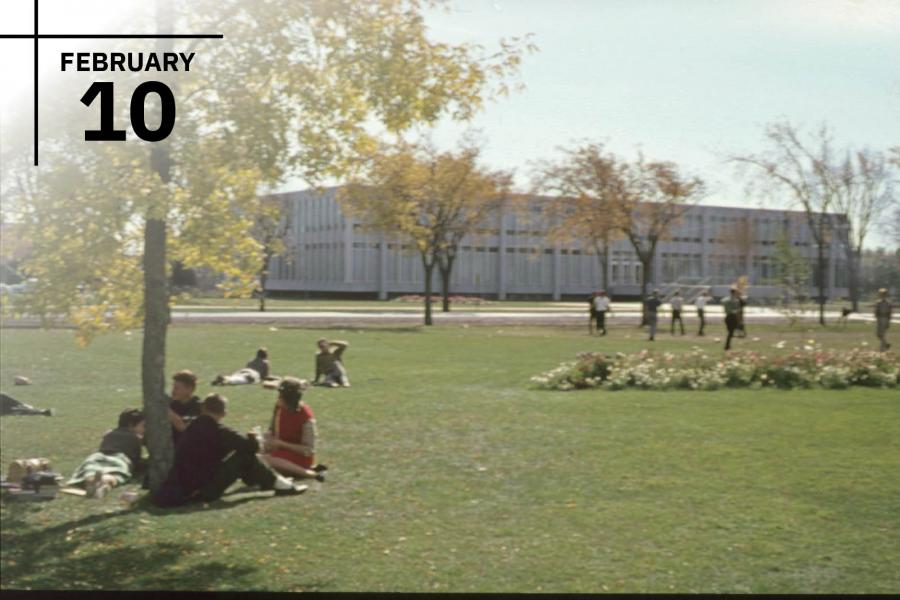 Groups of students seated outside of the John A. Russell building having picnics outside.