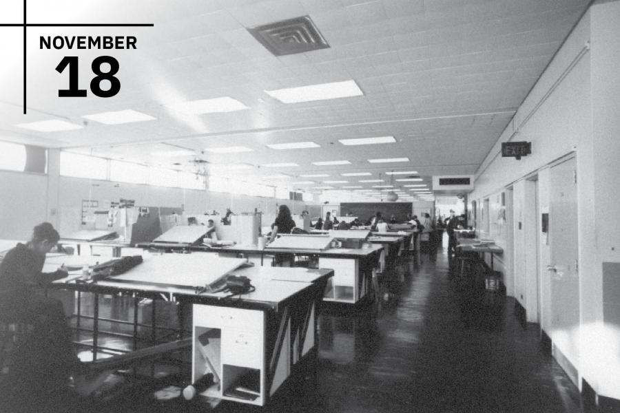 Students seated at their desks hunched over hand drafting architectural plans.