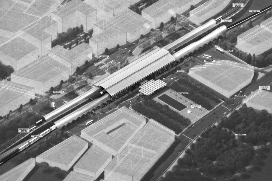 A grayscale aerial view of a train station shows platforms with trains, a covered structure, and surrounding roads. The setting is urban, emphasizing transport.