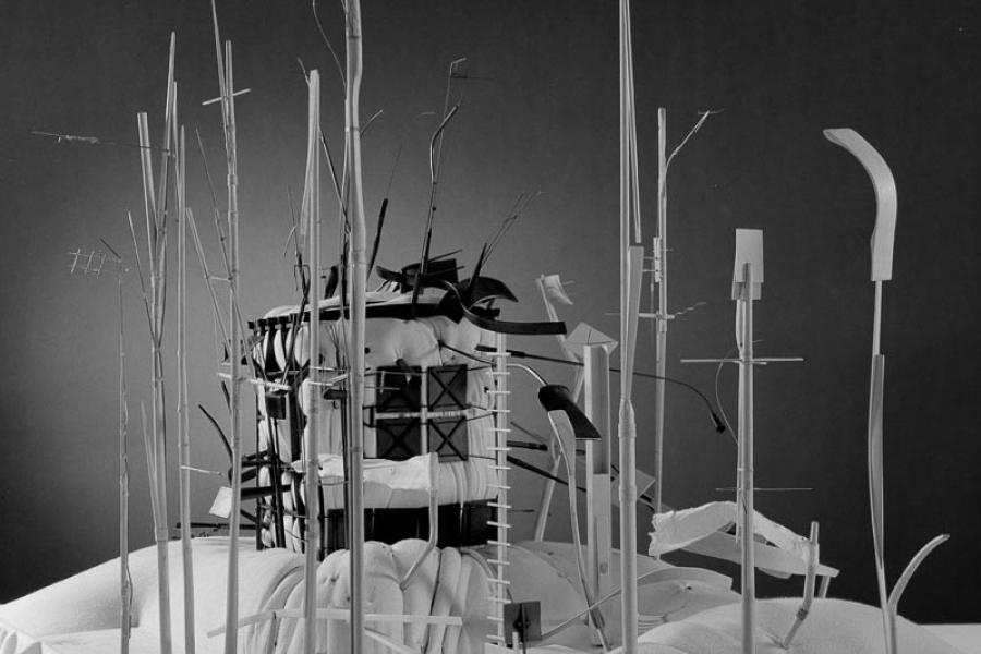 A black and white photo of an abstract architectural model with tall, thin structures and intricate geometric shapes, creating a futuristic and artistic atmosphere.