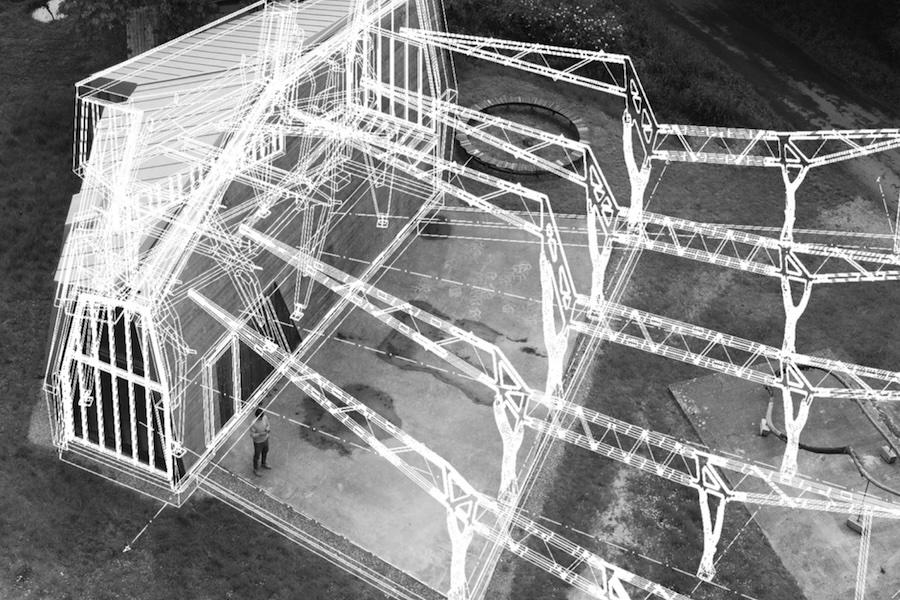 Wireframe overlay of a building structure on a grassy landscape. A person stands near the base, emphasizing the design's scale and detailed architecture.