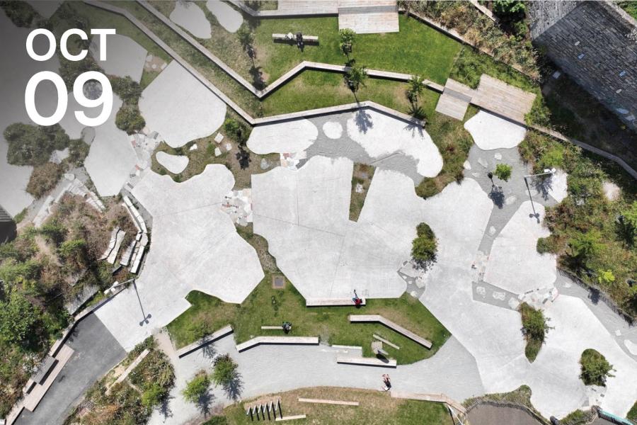 Aerial view of a geometric park with concrete paths and green patches.