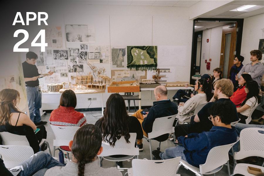 A man presents architectural models to an attentive audience in a classroom. The room is adorned with sketches and diagrams, creating an educational atmosphere.