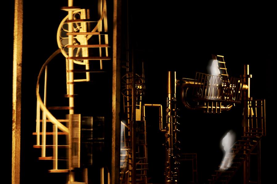 Golden abstract structures resembling ladders and spirals are set against a dark background. Semi-transparent, ghostly figures are ascending the structures. The scene is mysterious and surreal.