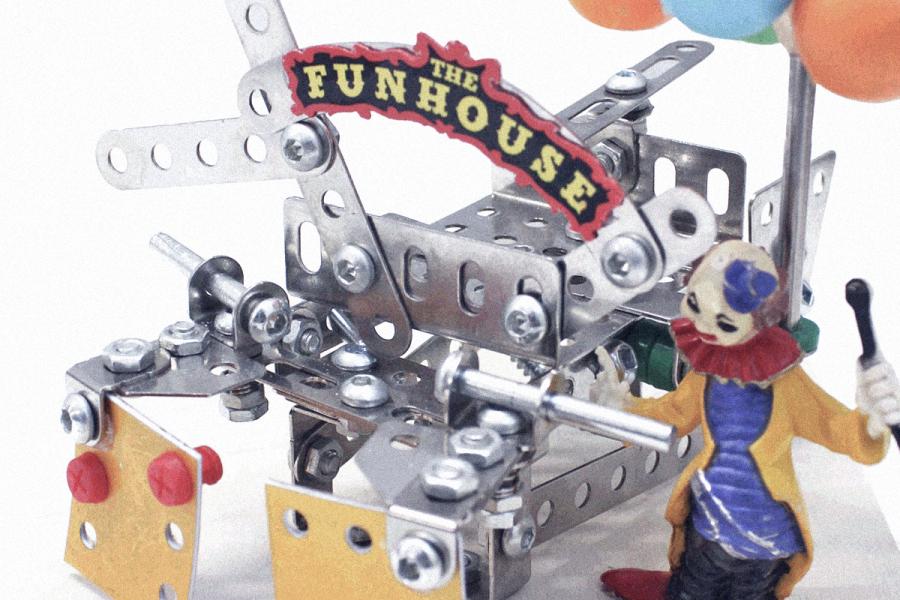 Metallic toy structure labeled "The Funhouse," with a colorful clown figurine and balloons, evokes a whimsical and playful carnival theme.
