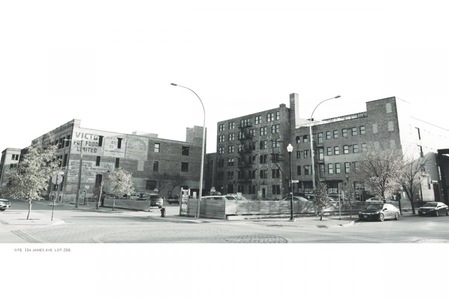 Vintage-style sepia photo of a street corner with brick buildings, trees, and parked cars. The scene appears calm and timeless.