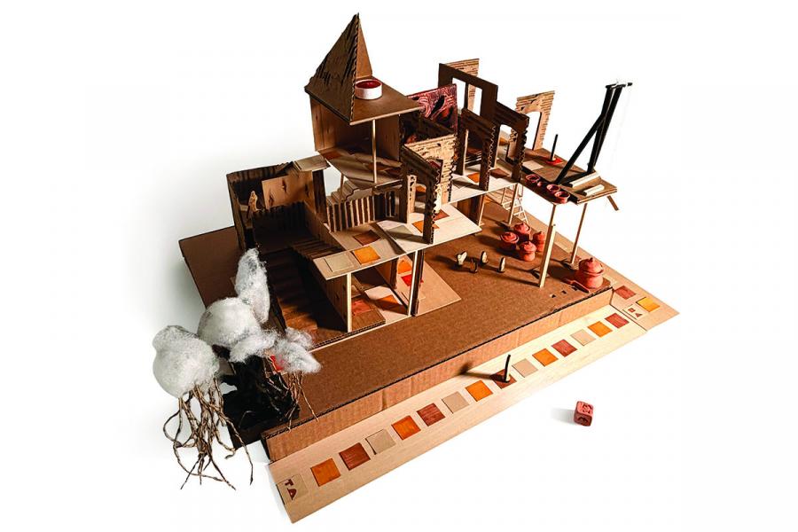 Architectural model of a multi-level structure made of cardboard, featuring abstract elements and stairs. Cotton-like trees add texture and depth.
