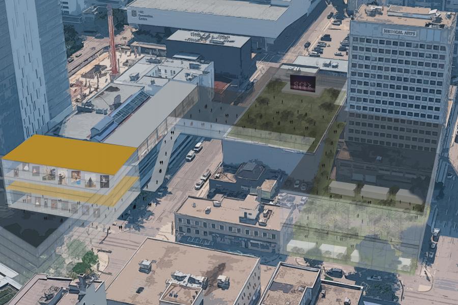 Aerial view of a cityscape showing a modern building with glass walls and a yellow roof connected by a skybridge. Rooftop gardens and streets below.