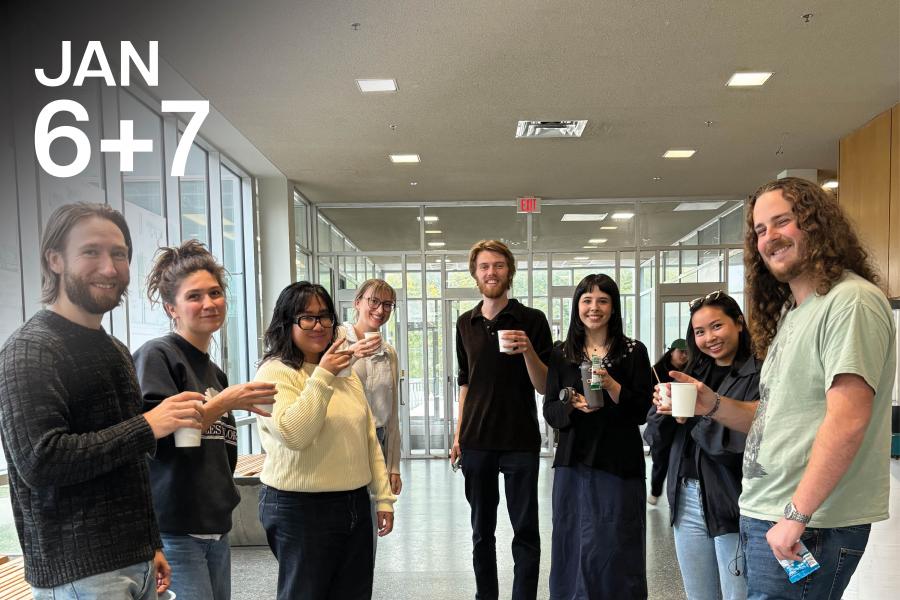 A diverse group of eight smiling people holding coffee cups in a modern, bright lobby with large windows.