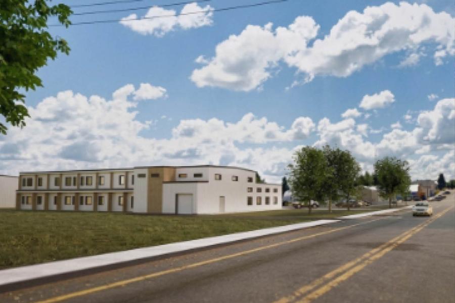 A modern building and lush green trees line the road, creating a serene atmosphere.