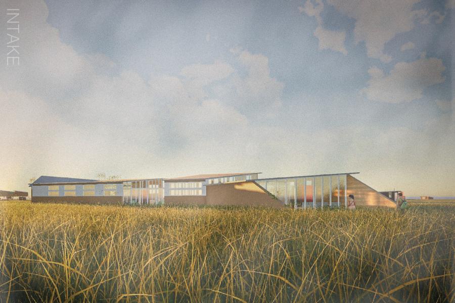A modern building with large windows in a grassy field under a blue sky with scattered clouds. 