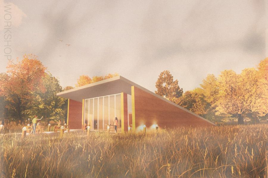 Modern, angular wooden building with large glass windows surrounded by autumn trees and grass.