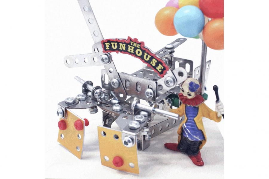 Toy model depicting a clown holding colorful balloons next to a metal contraption labeled "The Funhouse," evoking a whimsical, playful vibe.