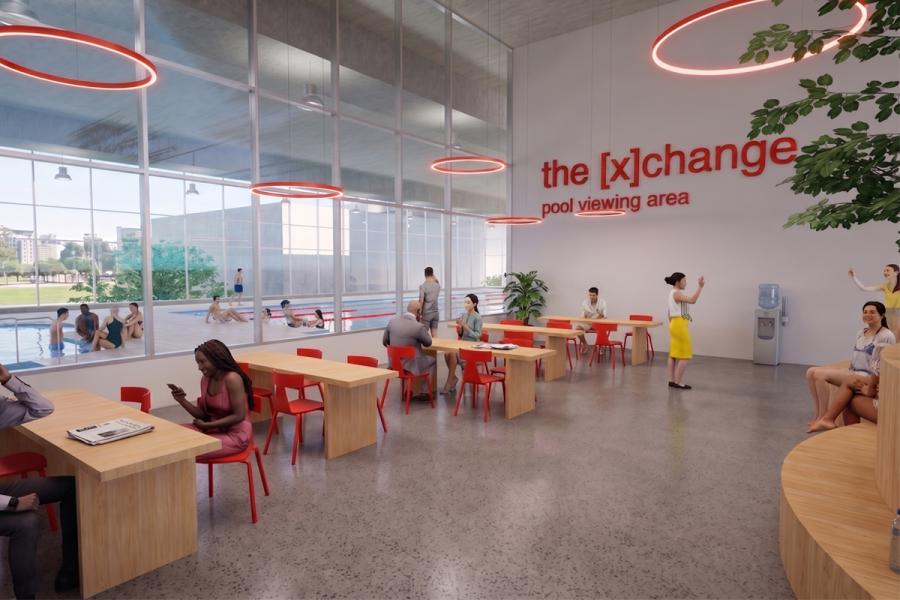 Modern pool viewing area with red chairs, wooden tables, and large windows overlooking swimmers.