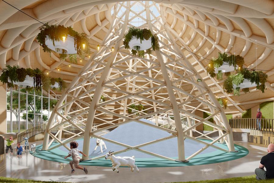 A spacious indoor playground with a large wooden lattice dome, hanging plants, and natural light. 