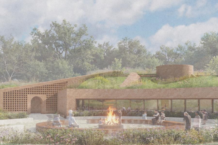 A serene scene features a circular, brick building with a green roof blending into the landscape.