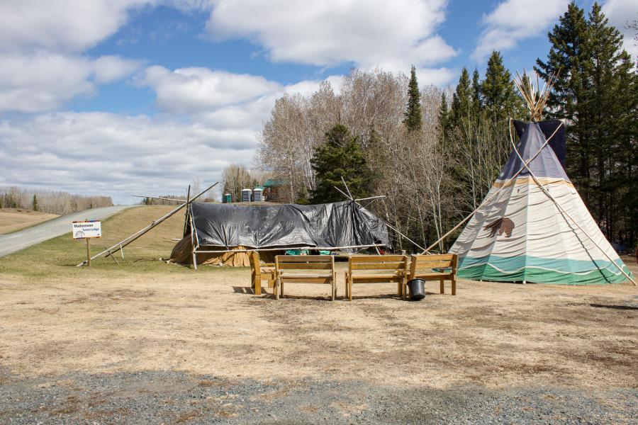 tipi and covered structure on vast plains