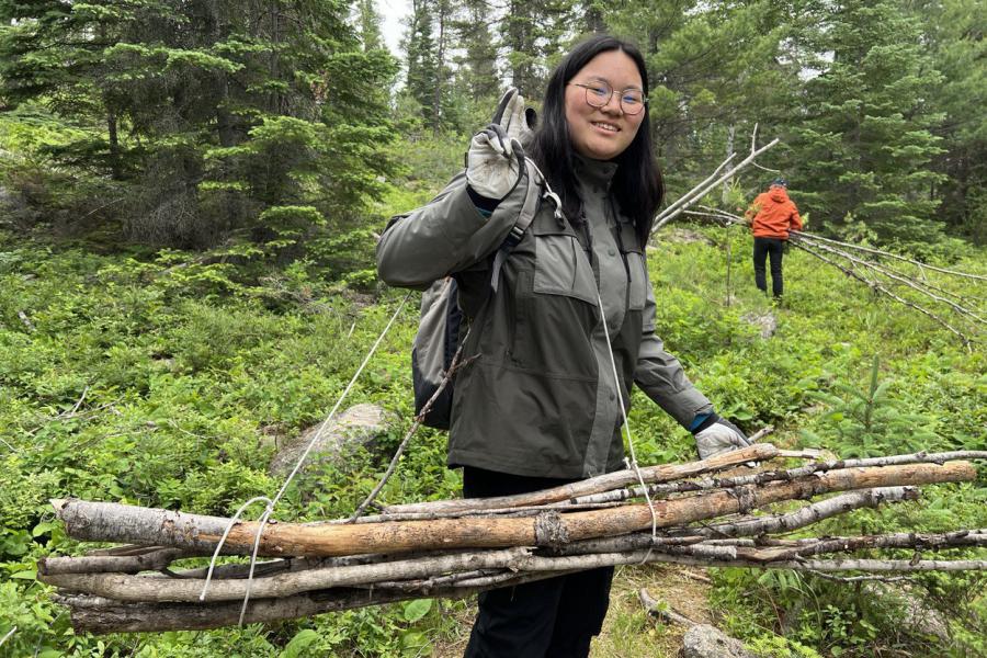girl carrying sticks