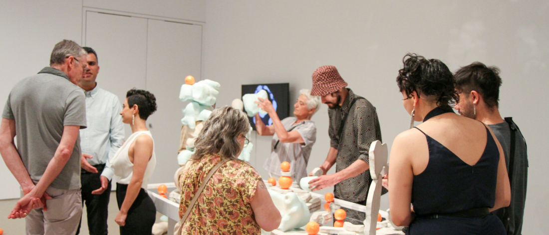 Visitors engaging with interactive sculptural installation during the exhibition reception.