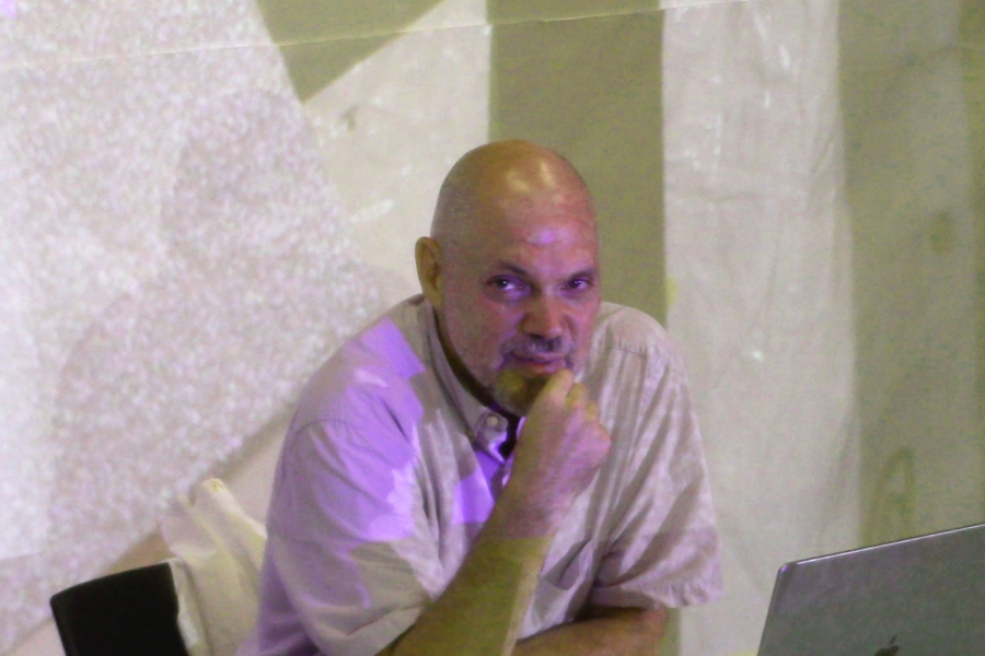 Derek Brueckner sits in a white polo shirt, looking towards the camera.