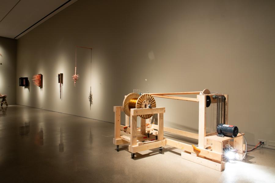 Mechanical wooden spool structure showcasing copper wire tension