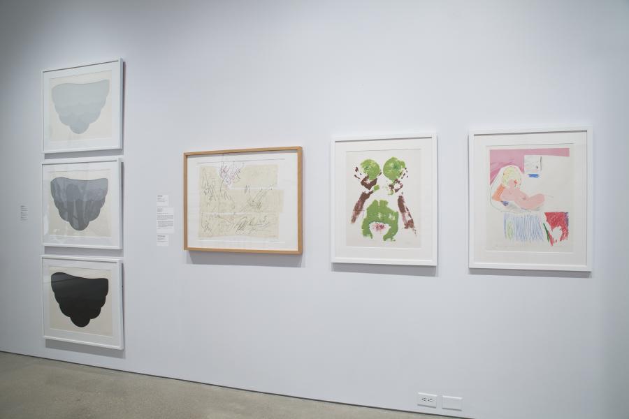 A selection of framed abstract and figurative artworks presented on a gallery wall with clean white framing.