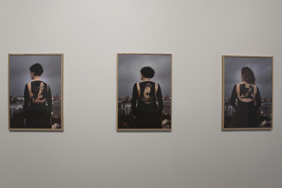 Three framed photographs of individuals wearing garments with ghostly imprints on their backs.