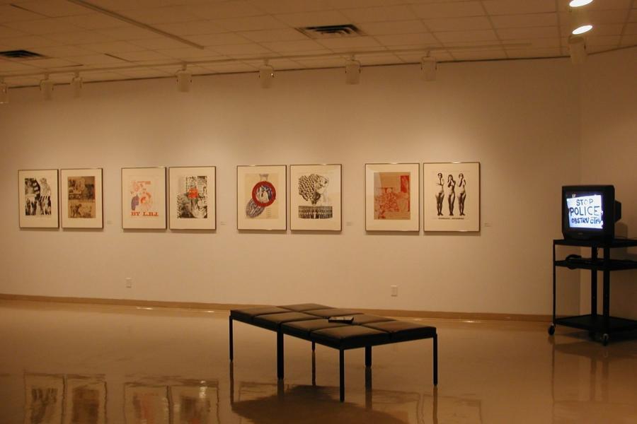 A wall of the gallery, with four diptych graphic collages printed in reds, blacks, and whites and hung in a row, a CRT television showing a protest sign reading “STOP POLICE OBSTRUCTION” on a stand in the wall’s right corner, and a bench in front of it. The furthest right graphic depicts three nude figures in black and white with their hands covering their faces.