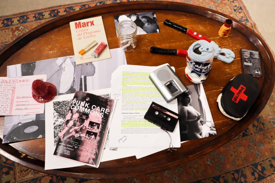 Close-up of archival materials, publications, and objects displayed on a coffee table.
